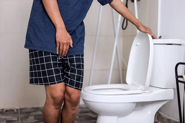 A man experiencing pain while using the bathroom
